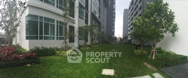 Modern apartment building with lush green garden and trees