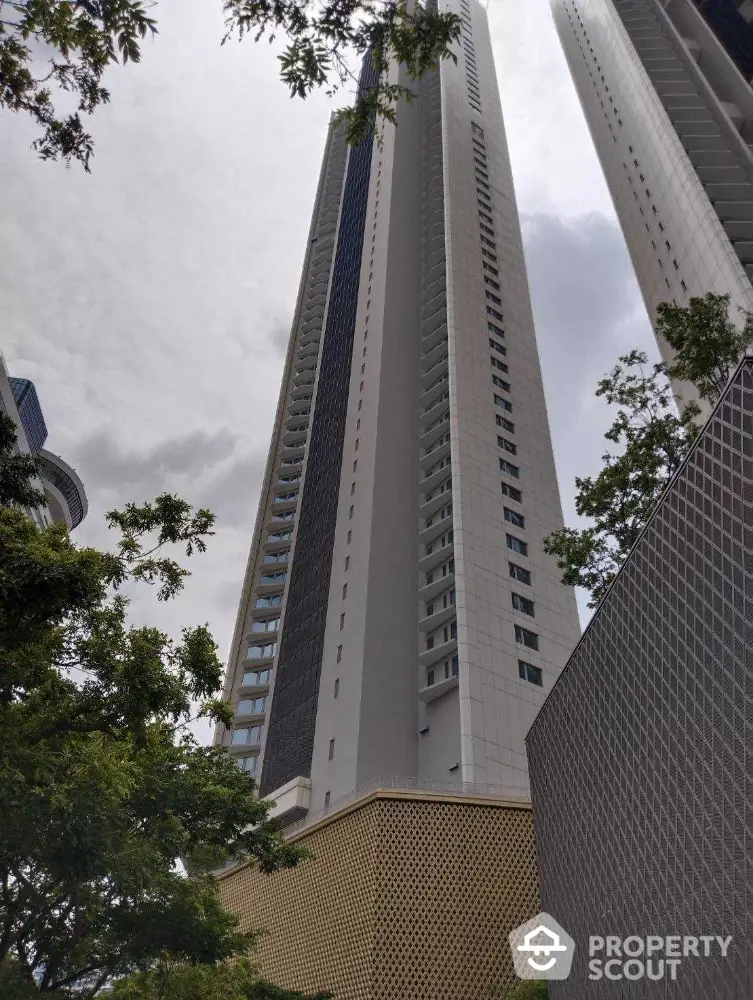 Stunning high-rise building with modern architecture and lush greenery in urban setting.