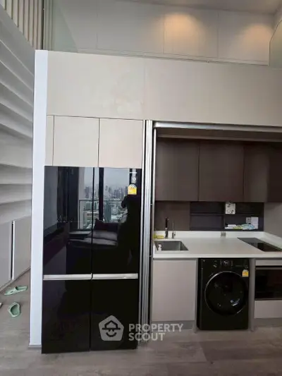Modern kitchen with sleek appliances and city view, featuring a washing machine and stylish cabinetry.