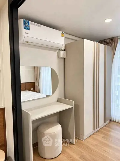 Modern bedroom with sleek wardrobe and vanity under air conditioning unit