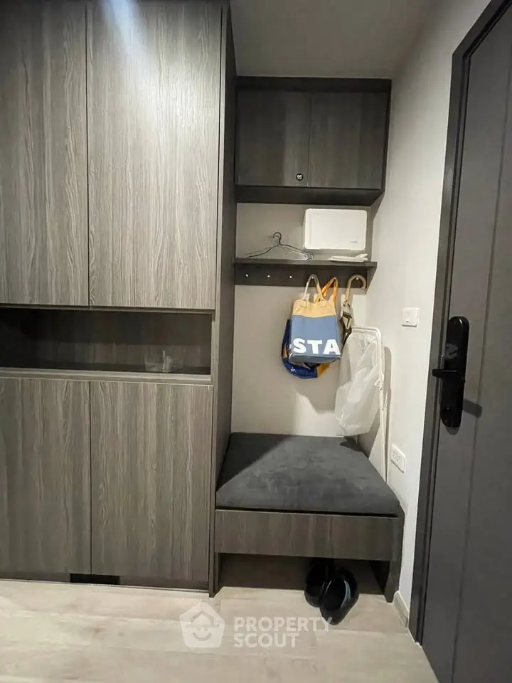 Modern entryway with sleek storage cabinets and cozy seating area