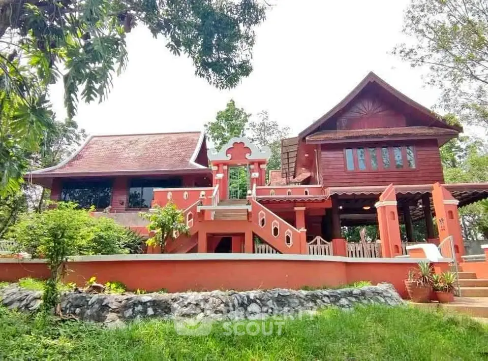 Charming traditional Thai-style house with lush garden and unique architectural features.