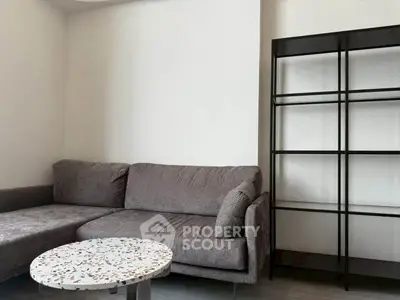 Modern living room with sleek gray sofa and stylish terrazzo coffee table.