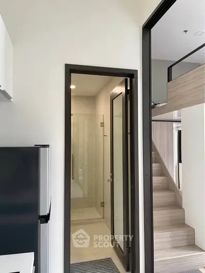 Modern interior with compact kitchen and loft stairs in stylish apartment