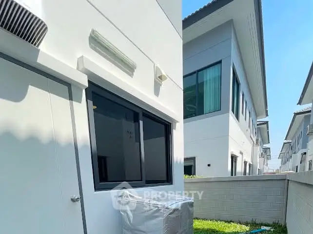 Modern residential building exterior with clean lines and large windows, showcasing contemporary architecture.