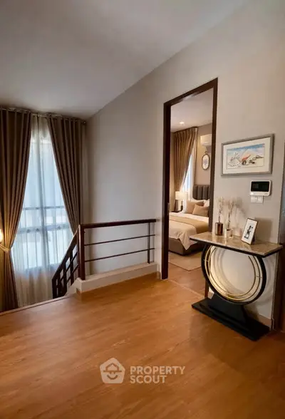 Elegant hallway leading to a cozy bedroom with stylish decor and warm lighting.