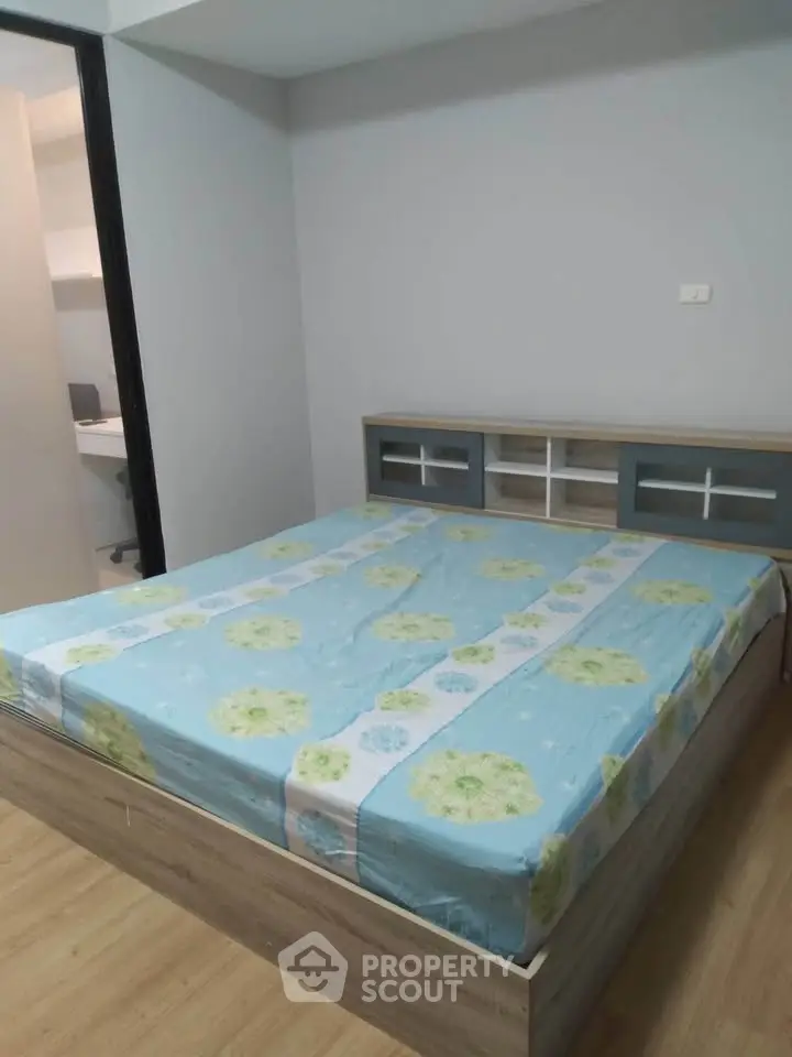 Spacious bedroom with modern bed and wooden flooring in a stylish apartment.