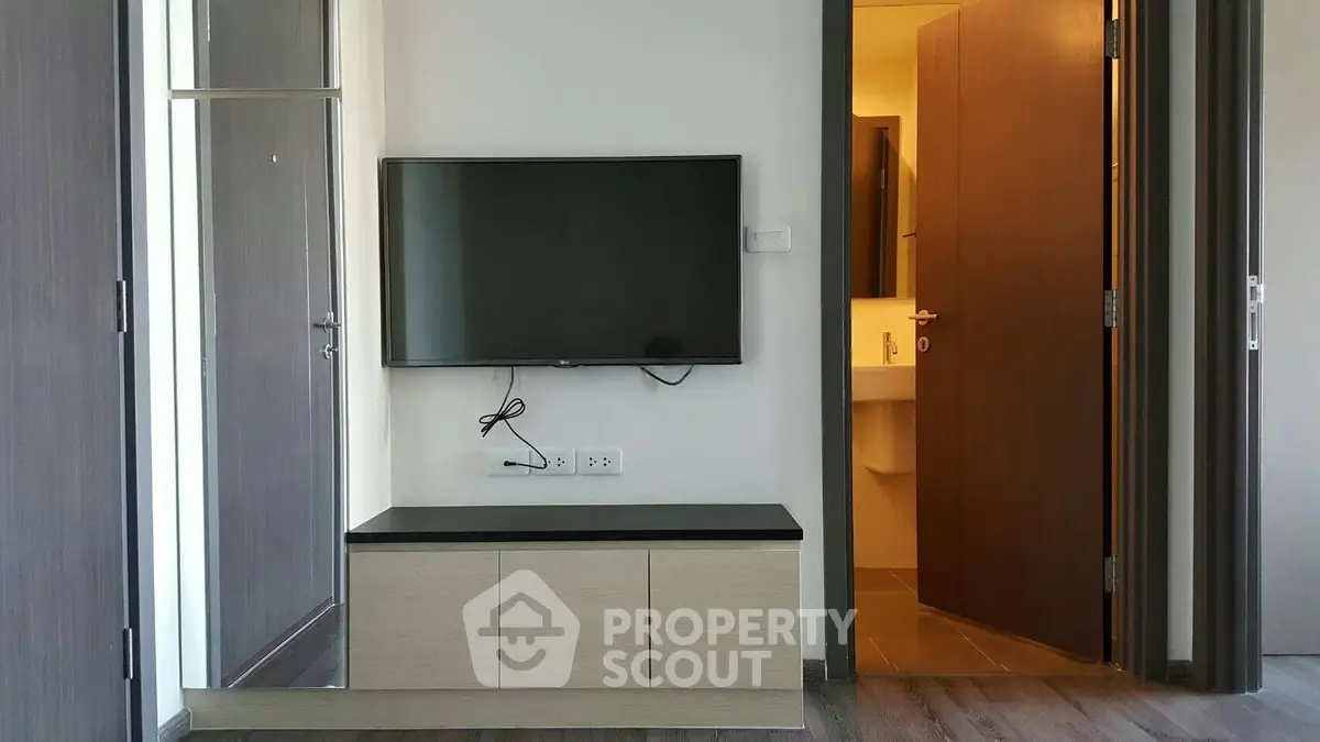 Modern living room with wall-mounted TV and sleek wooden cabinet