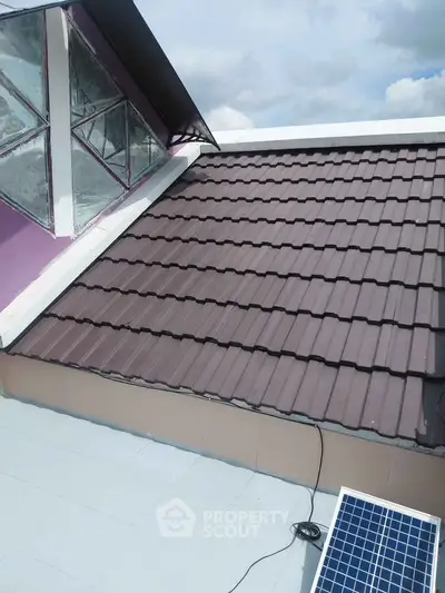 Modern rooftop with solar panel and skylight, showcasing sustainable architecture.