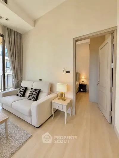 Modern living room with cozy sofa and elegant decor leading to a stylish bedroom.