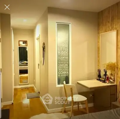 Cozy bedroom with wooden flooring and stylish decor, featuring a vanity desk and a hallway view.