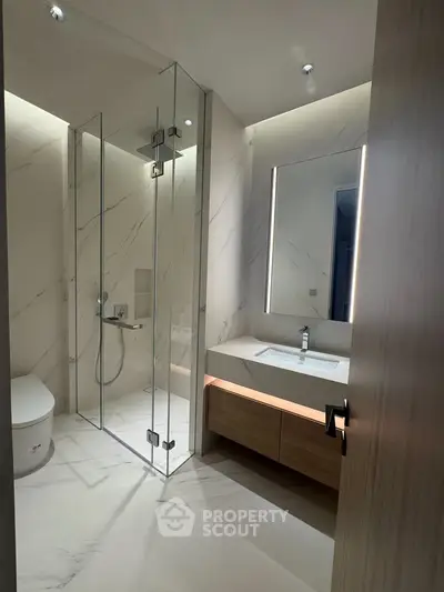 Luxurious modern bathroom with glass shower and elegant lighting