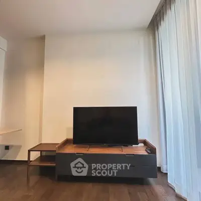 Modern living room with sleek TV stand and floor-to-ceiling curtains