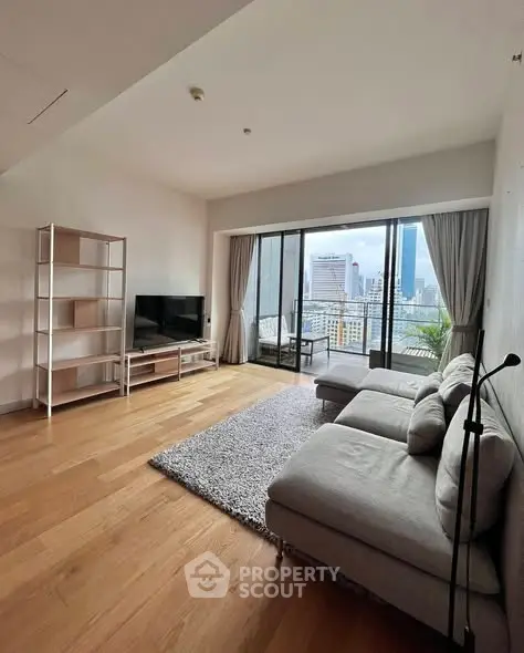 Spacious modern living room with city view and large balcony access.