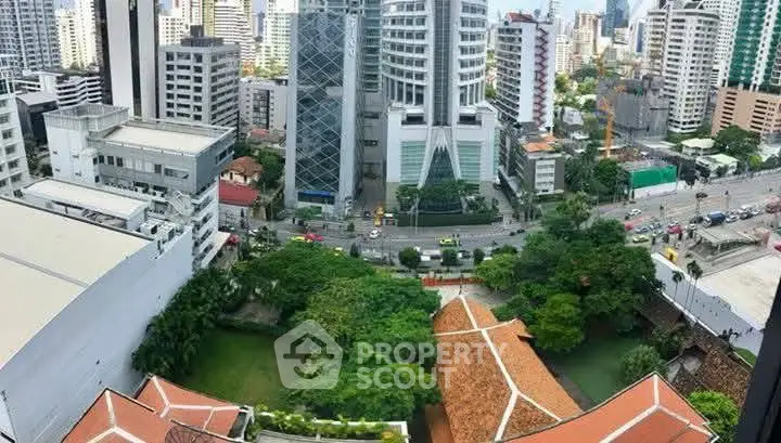 Stunning cityscape view from high-rise building with lush greenery and modern architecture.