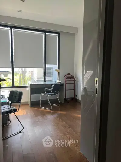 Modern study room with large windows and stylish furniture, perfect for productivity and comfort.