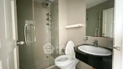 Modern bathroom with glass shower and sleek black countertop