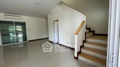 Spacious interior with modern staircase and glass doors, perfect for stylish living.