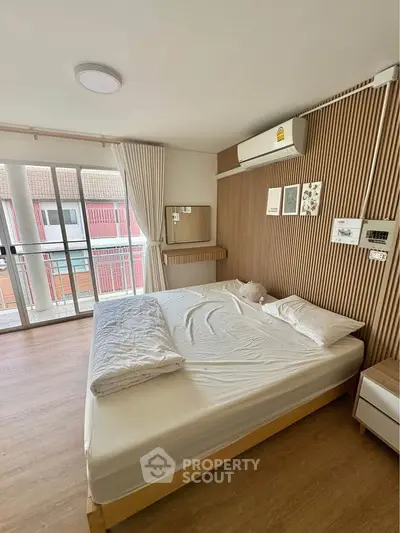 Modern bedroom with wooden accents and balcony view