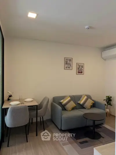 Cozy living room with modern decor and dining area in a stylish apartment.