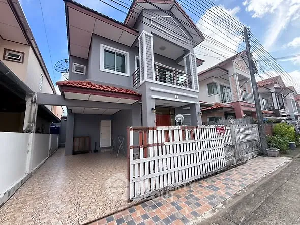 Charming two-story house with tiled driveway and balcony in a suburban neighborhood.