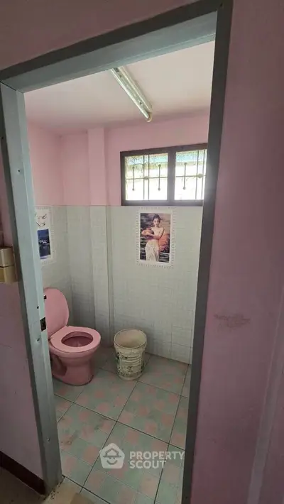 Charming pink-themed bathroom with vintage decor and natural light, perfect for a cozy home ambiance.