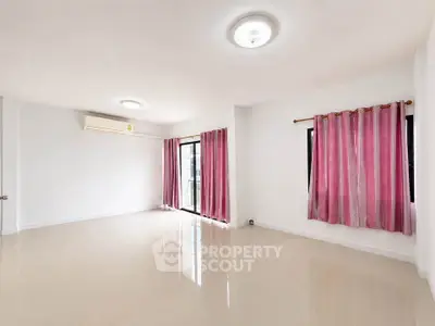 Spacious empty living room with pink curtains and air conditioning, perfect for customization.