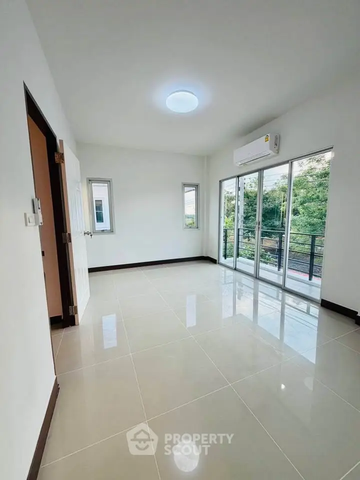 Spacious empty room with large windows and balcony access, perfect for customization.