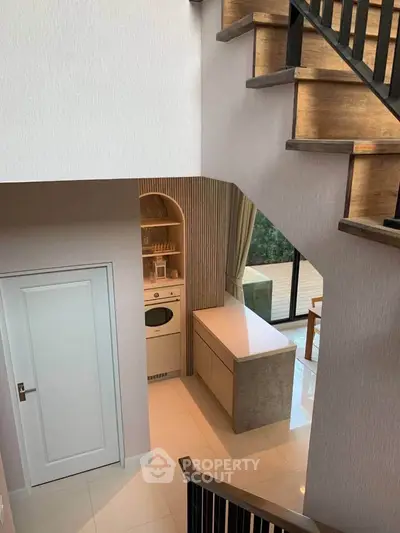 Modern interior with stylish staircase and compact kitchen area