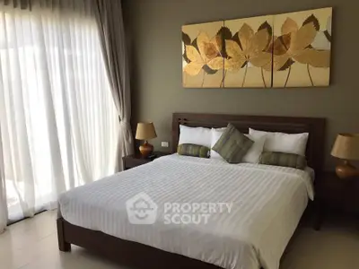 Elegant bedroom with large window, stylish decor, and cozy ambiance in modern home.