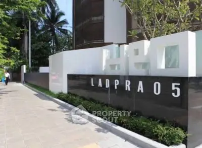 Modern building entrance with sleek design and lush greenery