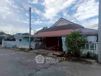 Charming suburban house with a red roof and fenced yard, perfect for family living.