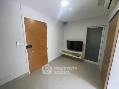 Modern minimalist living room with sleek tile flooring and wall-mounted TV