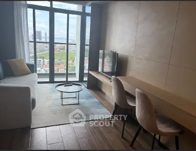 Modern living room with large windows offering stunning city views, stylish furniture, and elegant decor.