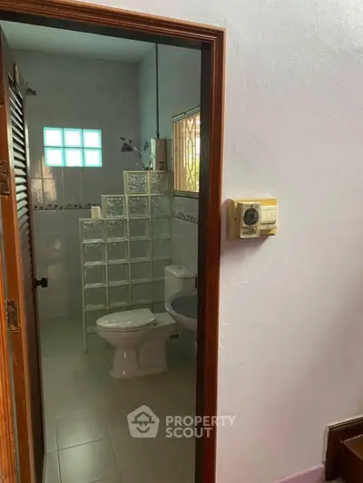 Cozy bathroom with glass block partition and modern fixtures