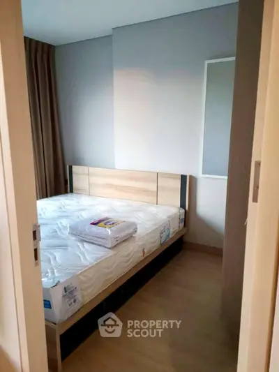Cozy bedroom with wooden flooring and modern bed frame, perfect for restful nights.