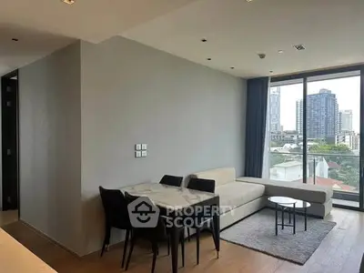 Modern living room with city view, featuring sleek furniture and large windows for natural light.