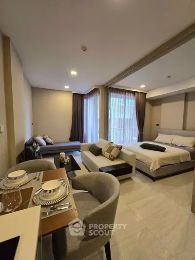 Modern studio apartment with open layout, featuring a cozy living area and elegant dining space.