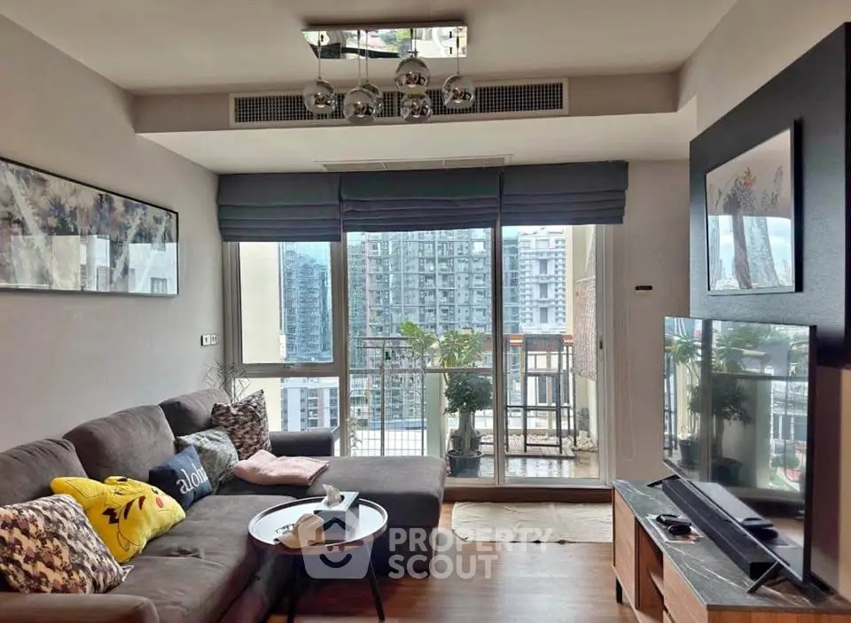 Modern living room with large windows and city view, featuring stylish decor and comfortable seating.