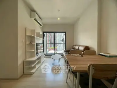 Modern living room with sleek furniture and large window offering city view