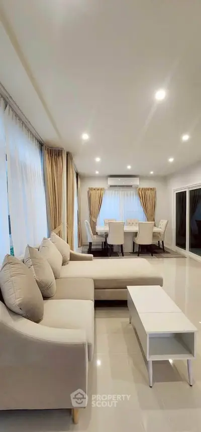 Spacious modern living room with elegant dining area and large windows