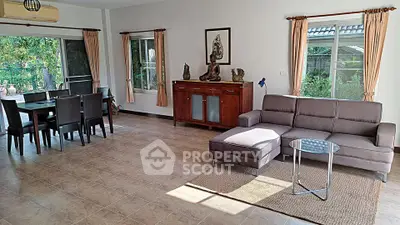 Spacious living room with modern furniture and garden view, perfect for family gatherings.