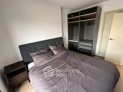 Modern bedroom with stylish wardrobe and cozy bedding in a contemporary apartment.