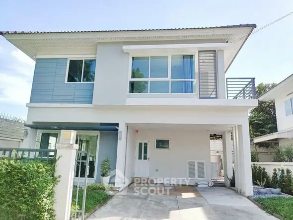 Modern two-story house with large windows and driveway in a suburban setting.