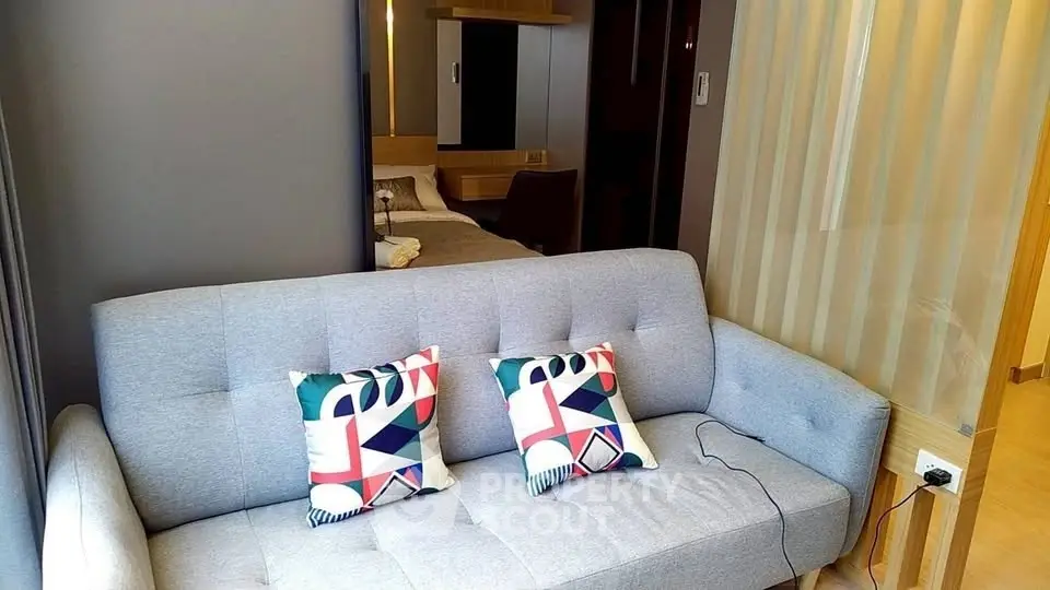 Modern living room with stylish sofa and colorful cushions in a cozy apartment setting.