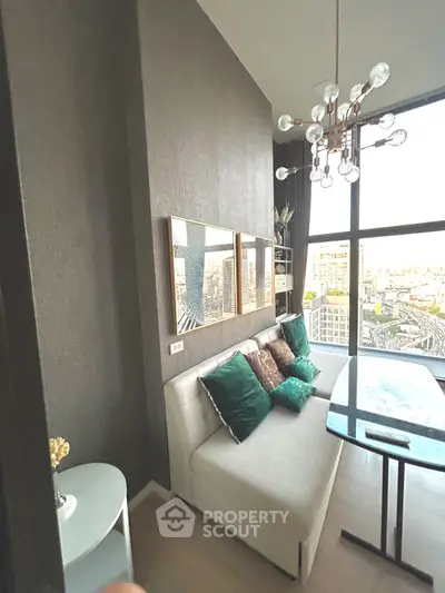 Modern living room with chic decor and stunning city view, featuring a stylish chandelier and comfortable seating.