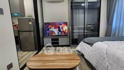 Modern studio apartment with cozy bedroom and sleek kitchen area, featuring stylish decor and a comfortable ambiance.