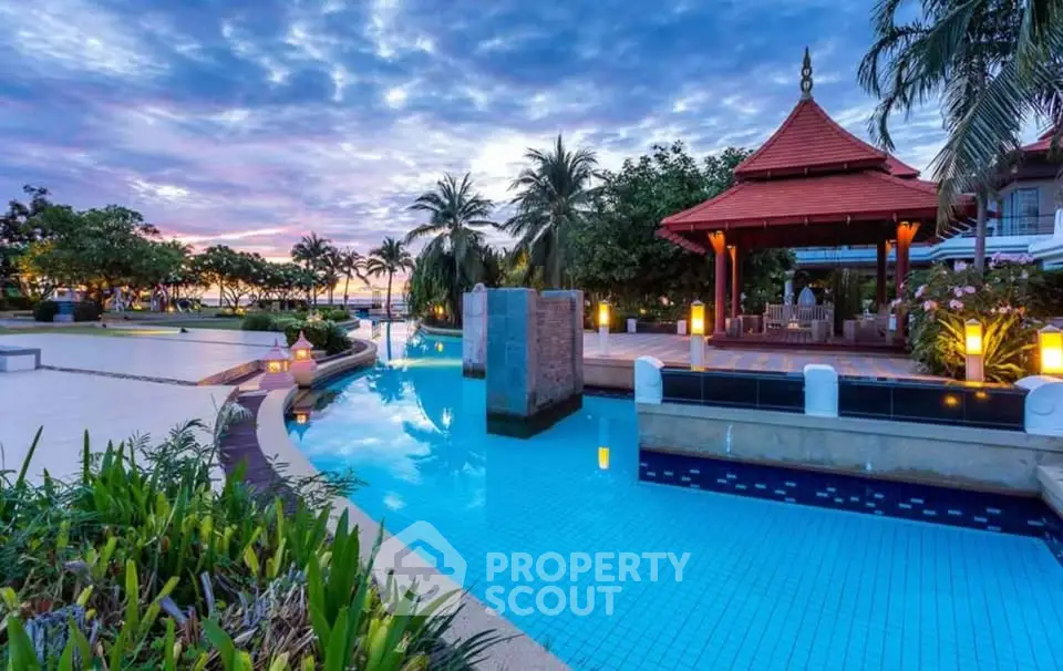 Luxurious tropical resort pool with stunning sunset view and lush greenery.