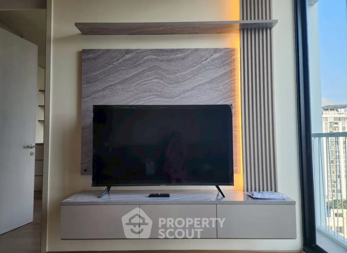 Modern living room with sleek TV unit and balcony view