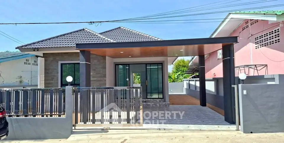 Modern single-story house with sleek design and spacious driveway.